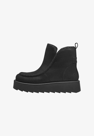Schwarze Knöchelstiefel aus strukturiertem Stoff, mit einer stabilen Plattformsohle, gesteppten Details entlang der Kanten und einer Zuglasche an der Rückseite.