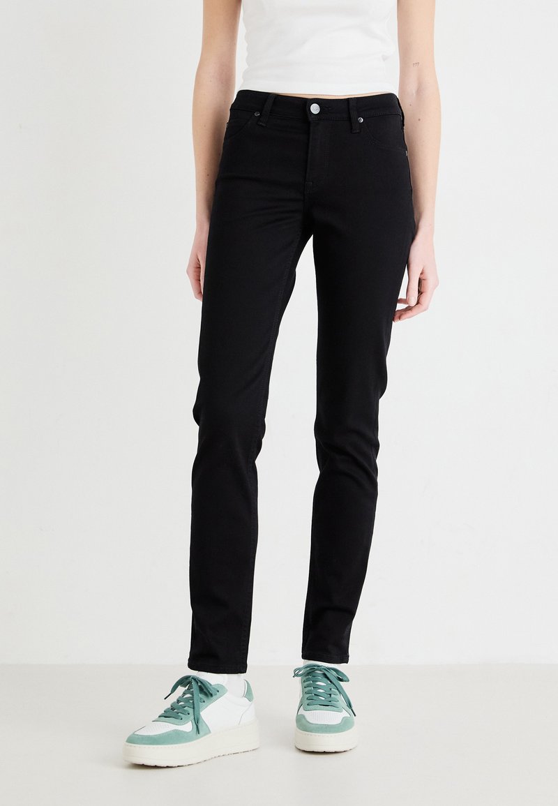Svarta jeans med smal passform och standard femfickorsdesign, med silverfärgad metall och en mjuk, hållbar tygtextur.