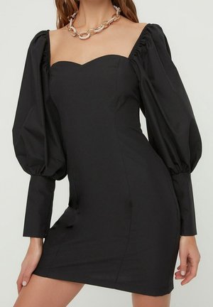 Zwart mini-jurkje met een sweetheart halslijn, pofmouwen en een aansluitende pasvorm, gemaakt van gladde stof met een strakke textuur.
