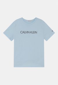 Helles blaues Baumwoll-T-Shirt mit rundem Halsausschnitt und kurzen Ärmeln. Auf der Vorderseite steht der Text "CALVIN KLEIN" in dunkler Schrift.