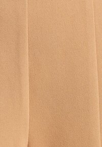 Beige stof met een gladde textuur, met een subtiele matte afwerking, die een lichte rek vertoont en een nette snit heeft zonder zichtbare naden.