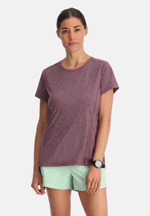 T-shirt maroon con maniche corte e colletto rotondo, realizzato in tessuto leggero. Abbinato a pantaloni corti verde menta e a un orologio nero.