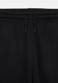Un pantalon de survêtement noir avec une taille élastique, des cordons de serrage ajustables et une texture de tissu lisse.