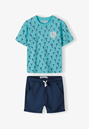 Hele sinine lühikeste varrukatega t-särk, millel on palmipuude trükk ja tekst "CHILL OUT". Tumesinised lühikesed püksid küljetaskutega ja elastse vööga.