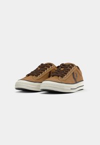 Brūni zamšaini zemi topi sneakers ar tumši brūnām auklām, baltu gumijas zoli un zvaigznes akcentu sānos. Klasisks ikdienas dizains.