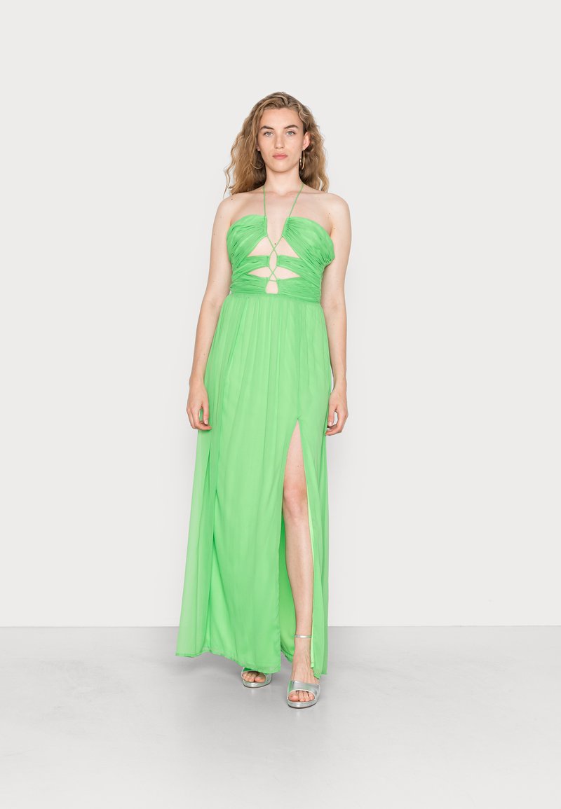 Vestido maxi verde, sem alças, com um corpete justo, detalhes recortados e uma saia fluida com uma fenda lateral. Textura de tecido suave.