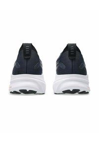 Marine blauwe sportschoenen met een gestructureerde bovenkant, witte zool en zwarte rubberen buitenzool. Voorzien van een trekband en subtiele branding op de achterkant.