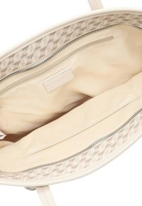 Sac fourre-tout beige avec un extérieur lisse, comportant un intérieur doublé, une poche zippée, et des accents à motif géométrique le long de la couture supérieure.
