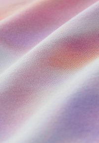 Weiches Textil mit einem Farbverlauf aus hellrosa, lavendel und orange Tönen. Glatte Textur mit einer leicht reflektierenden Oberfläche.