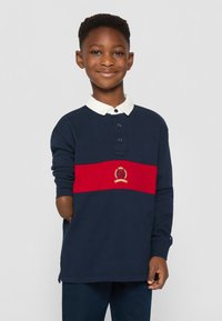 Granatowa, długosylenowa koszulka polo z białym kołnierzykiem, z czerwoną poziomą paską i haftowanym logo w kolorze złotym. Wykonana z bawełny.