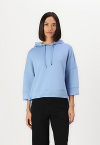 Felpa azzurro chiaro con cappuccio regolabile, maniche 3/4 e lacci laterali. Realizzata in materiale morbido con una texture liscia.