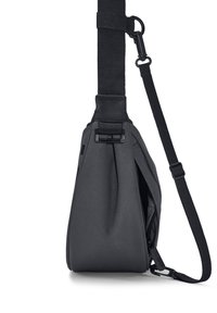 Čierna látková taška na rameno so štíhlym tvarom, nastaviteľným popruhom a zipsovými detailmi. Disponuje jemnou štruktúrou a minimalistickým dizajnom.