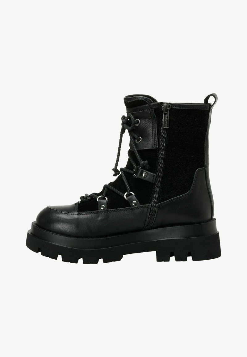 Must must jalatsid tekstureeritud ülaosa ja sileda nahkpaneeliga, külgmise tõmbluku, paksu tallaga ja dekoratiivsete metallist detailidega.