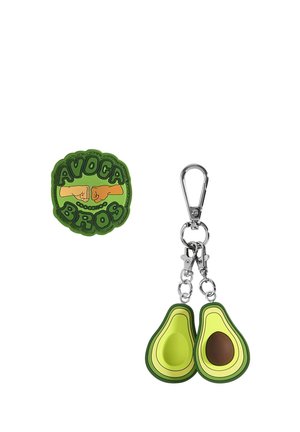 Avocado-shaped keychain in green rubber with brown accents, featuring two halves and silver metal hardware. Includes "AVOCA BROS" patch.