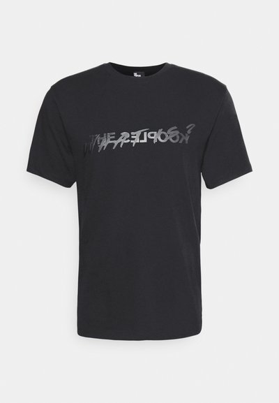 Black cotton t-shirt with short sleeves, featuring a distorted, reflective text print in silver across the chest. Casual fit.