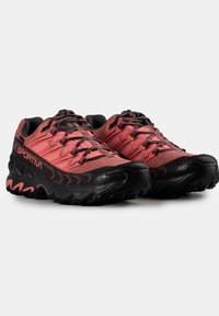 Červené a černé trailové běžecké boty s hodně prodyšným svrškem, strukturovanou gumovou podešví a vzorovanými detaily. Obsahují zesílenou špičku a systém šněrování.
