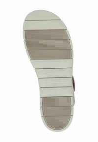 Suola delle scarpe con un design testurizzato; materiale beige chiaro che presenta scanalature orizzontali e sottili accenti verticali per la presa e la trazione.