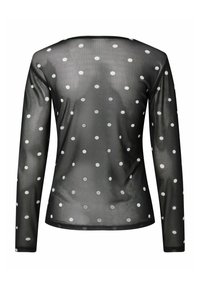 Czarna bluzka z długim rękawem o prześwitującej fakturze, zdobiona równomiernie rozmieszczonymi białymi kropkami. Okrągły dekolt i obcisły krój.