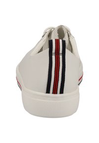 Sneaker bianca con superficie testurizzata, caratterizzata da un accento tessile a righe in rosso e blu marino sul tallone e una suola in gomma solida.