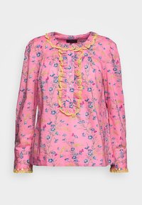 Rosa långärmad blus med blommönster i blått och gult, med rynkad krage och knapprad, accentuerad med gula detaljer.