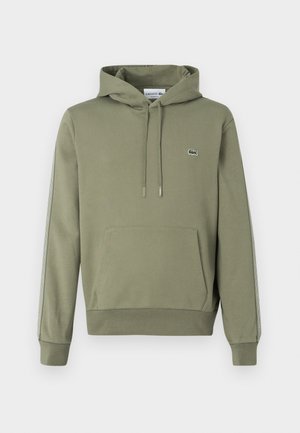 Sudadera verde oliva con un bolsillo frontal, capucha ajustable con cordón y rayas laterales que presentan un discreto logotipo de la marca. Tejido de mezcla de algodón.