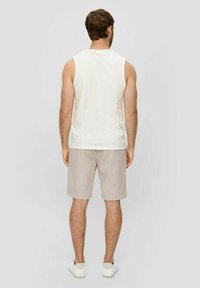 Weißes ärmelloses Tanktop, hellbeige Shorts und weiße Schuhe. Leger-outfit mit glatter Textur und entspannter Passform.