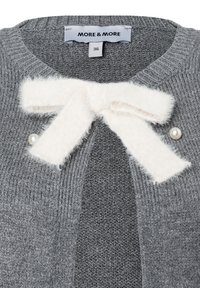 Grauer gestrickter Pullover mit einer weißen, flauschigen Schleife am Kragen und zwei Perlenknöpfen auf beiden Seiten der Öffnung.