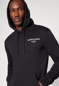Björn Borg ESSENTIAL HOODIE - Jersey con capucha - black beauty