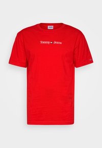 Červené bavlněné tričko s kulatým výstřihem a krátkými rukávy. Logo "Tommy Jeans" zobrazené bílým písmem přes hrudník.