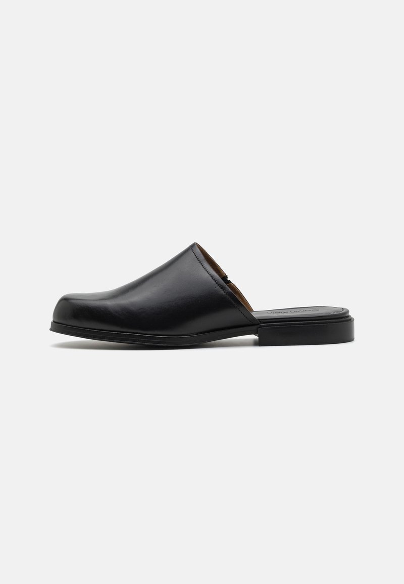 Černá kožená slip-on bota s kulatou špičkou, hladkým povrchem, minimalistickým designem a nízkým obdélníkovým podpatkem. Vhodná na volný čas.