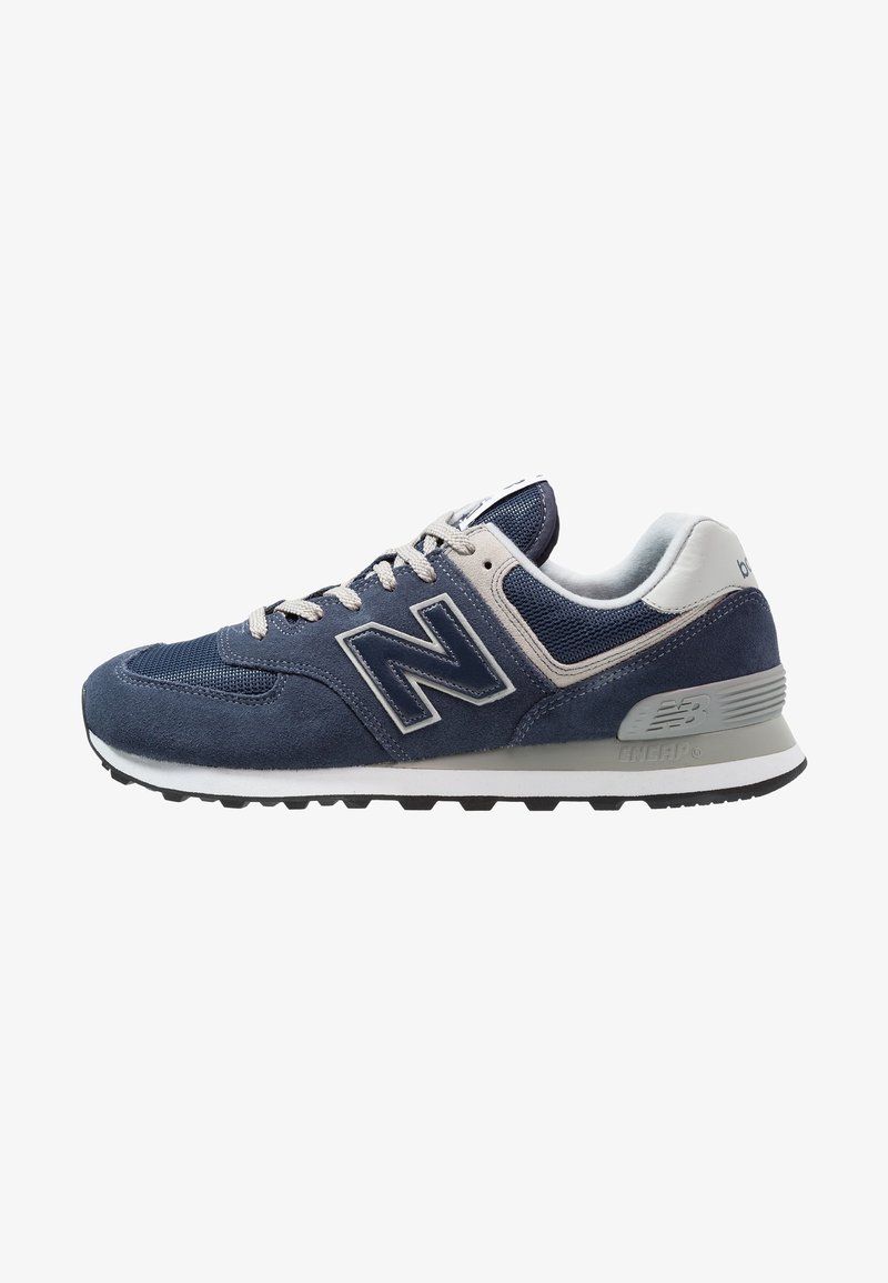 Baskets New Balance bleu marine et grises avec dessus en mesh et suède, lacets blancs et semelle en caoutchouc noire vues de côté.