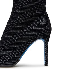 Stivale nero con tacco alto, caratterizzato da una trama a zigzag, con punta affusolata e un dettaglio blu sul tacco. Materiale liscio e lucido.