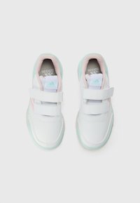 Baskets blanches avec des accents roses et menthes, des bandoulières Velcro et un matériau lisse. Présente un bout arrondi et une semelle texturée.