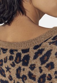 Stickad tröja med leopardmönster i nyanser av brunt och svart, med en vid halsringning och strukturerad tyg.