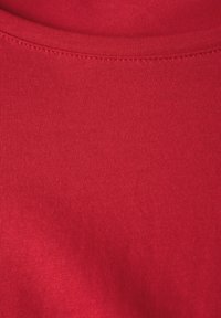 Rotes Baumwollhemd mit glatter Textur, Rundhalsausschnitt und ordentlich genähtem Saum und Kragen.