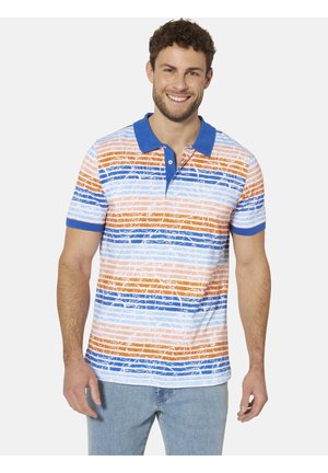 Lächelnder Mann, der ein kurzärmeliges Poloshirt mit blauem Kragen und orange-, blau- und weiß gestreift trägt, kombiniert mit hellblauen Jeans.