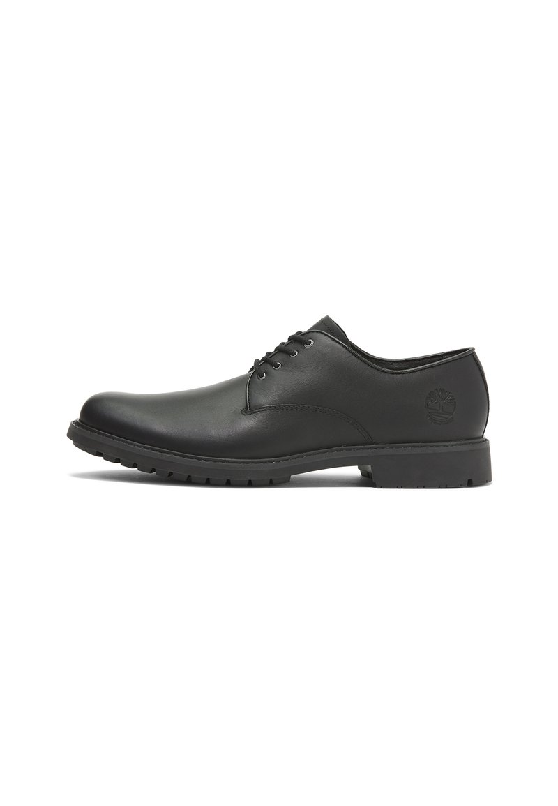 Scarpa da uomo in pelle nera con punta tondeggiante, lacci, superficie texture e suola in gomma con piccole scanalature per la trazione.