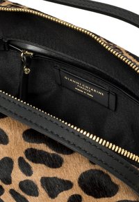 Borsa con stampa leopardata, con cerniera dorata, foderata internamente di nero e un'etichetta nera che recita "Gianni Chiarini Firenze made in Italy."