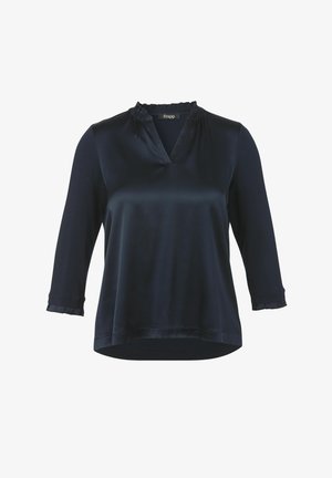 Blouse en satin bleu marine avec un col en V, un col volanté et des manches ¾ présentant des poignets texturés ; finition lisse et coupe décontractée.