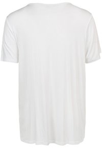 Vit kortärmad t-shirt, tillverkad av mjukt tyg, har en avslappnad passform med rundad halsringning och slät, jämn textur.