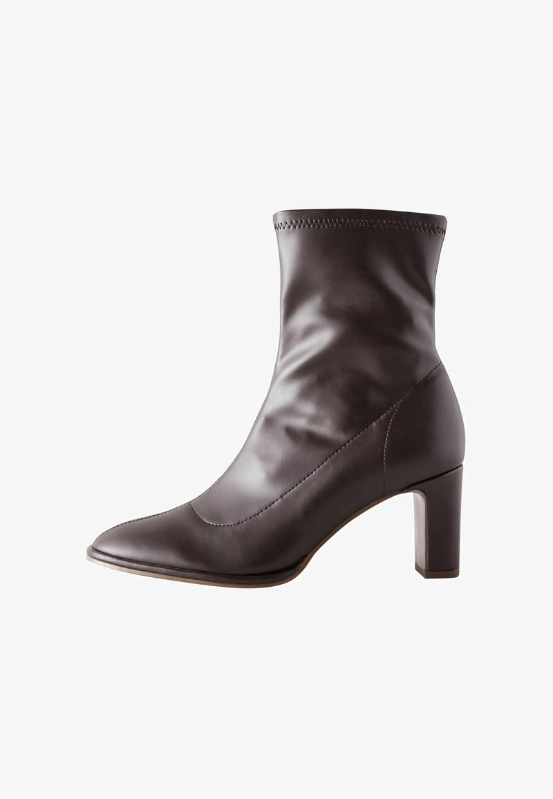 Stivale alla caviglia in pelle marrone con punta affusolata, superficie liscia e tacco quadrato. Presenta cuciture decorative attorno al bordo superiore.