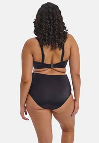 Černý dvoudílný bikini s podprsenkou na nastavitelné ramínka a zapínáním na zádech, doplněný o vysoké kalhotky. Hladká textura látky.