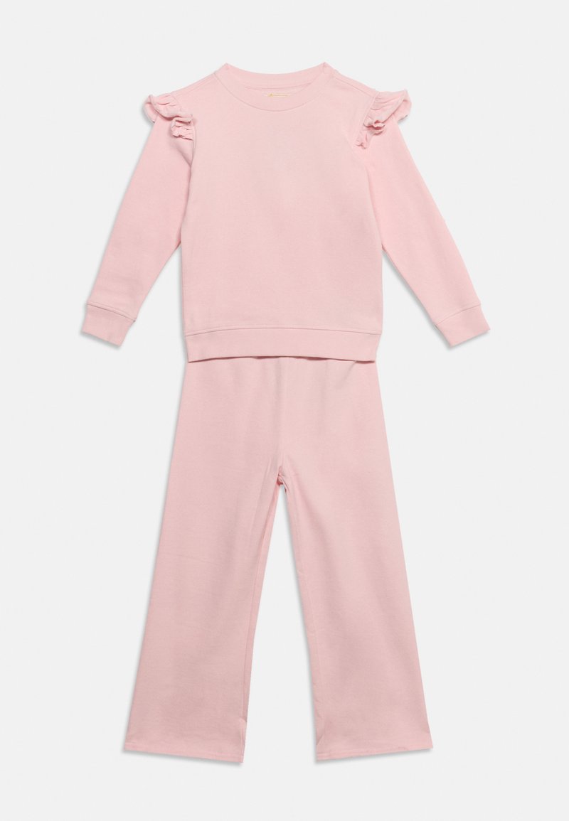 Haut à manches longues rose clair avec volants aux épaules et pantalon ample assorti, posé à plat sur un fond blanc.