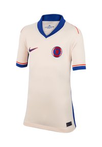 Maglietta da calcio color crema con accenti blu e arancioni, colletto a V, maniche corte e logo rotondo della squadra sul petto.