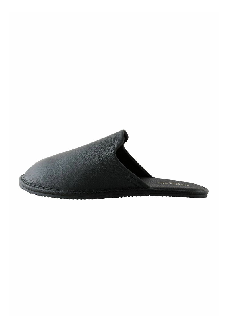Black leather slip-on slipper with a rounded toe and textured finish. Features a flexible sole and minimalistic design.