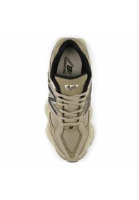 Bež New Balance 9060 tossud, millel on võrgust ja sünteetilisest materjalist pealmine osa, mustade aktsentide, paelte, logo ning tekstureeritud vahevaiba omadustega.