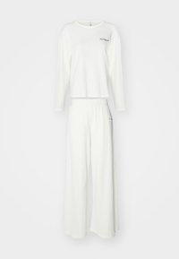 Blusa branca texturizada de manga longa com decote redondo e calças largas a condizer com cintura elástica e um discreto detalhe de bordado.