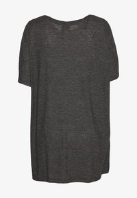 Tmavě šedé tričko s krátkým rukávem a volným střihem. Měkká, texturovaná látka s kulatým výstřihem a mírně delším zadním dílem.