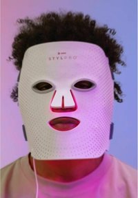 Masque facial en silicone blanc avec perforations, comportant des découpes pour les yeux et la bouche, logo affiché sur le front, relié à un fil.