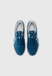 Baskets de sport bleues avec une tige en mesh, des accents blancs et un col rembourré. Elles présentent un design de lacets plats et une semelle texturée pour une meilleure adhérence.